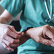 Nurse fitting patient with monitoring technology