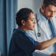 nurse and physician collaborate over desktop computer in patient room