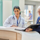 clinicians and administrators collaborate at hospital desk