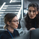 cybersecurity team members talk in front of monitors