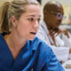 nurses talk in front of desktop computer