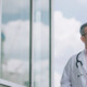 doctor in front of clouds and reflective building