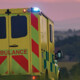 ambulance driving down country road at sunset