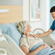 nurse cares for senior in hospital bed