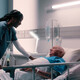 nurse talks to patient in hospital bed