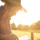 farmer on tablet in field at sunset