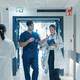 clinicians walk down busy hospital hallway