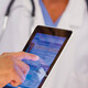 nurse and doctor look at EHR on tablet and monitor