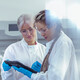 researchers discuss data on tablet in lab