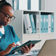 nurse using tablet and laptop at desk