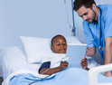 Male nurse and patient using digital tablet in ward