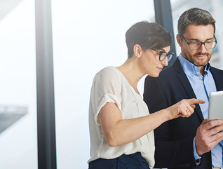 Shot of a team of colleagues using a digital tablet together at work