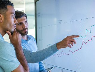 Businessman explaining line graph to his coworker.