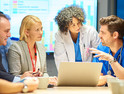 Doctors and business teams collaborating around computer