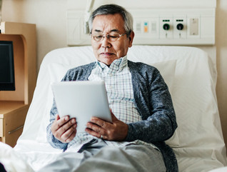 Man Reading on iPad in Hospital Room