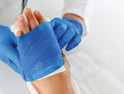 doctor dresses patient's wound on hand