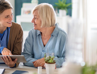 nurse and older adult look at tablet