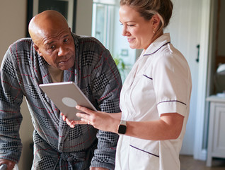 nurse and senior look at tablet together