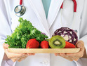 Doctor holds tray of fruit and vegetables