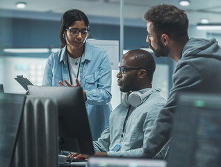 three security team members having a discussion over computer