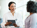 clinician talks with patient while holding tablet