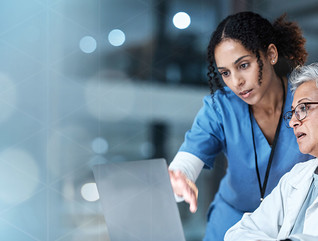 nurse and physician collaborate over laptop