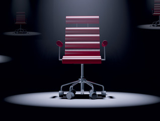 red office chair spotlit in a dark room