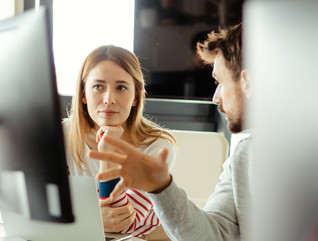 IT staff talk in front of monitor