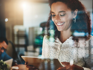 smiling woman looks at tablet in office