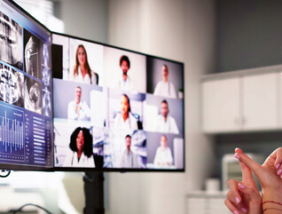 doctor on video call with several care team members