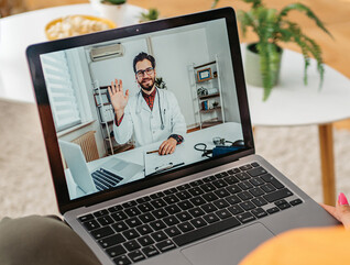 patient on laptap doing a telehealth call with doctor