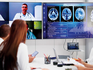 healthcare professionals participate in a hybrid meeting