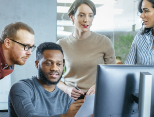 IT team discuss problem around computer
