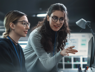 two IT leaders discuss cybersecurity in front of computer