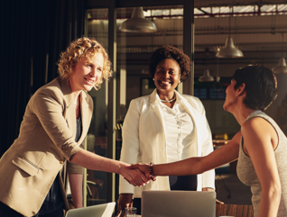 business leaders shake hands in conference room