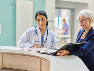 clinicians and administrators collaborate at hospital desk