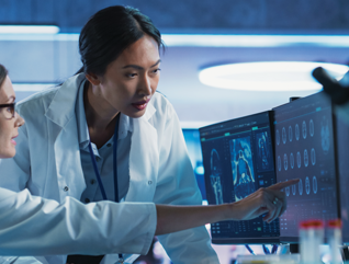 medical researchers looks at images on a monitor in a lab