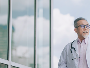 doctor in front of clouds and reflective building