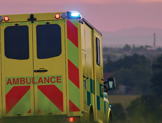 ambulance driving down country road at sunset