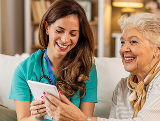 nurse and senior look at technology