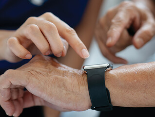 nurse helps man with wearable device