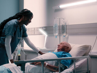 nurse talks to patient in hospital bed