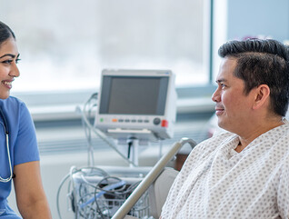 nurse talks with patient in hospital room