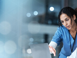 doctor and nurse look at laptop