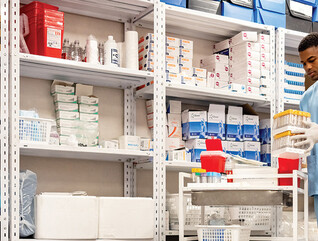 man grabs supplies in pharmacy supply room