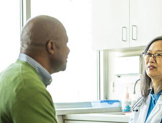 doctor talks with patient in exam room