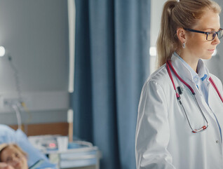 doctor looks at data on computer at the bedside
