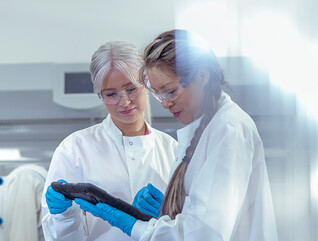 researchers discuss data on tablet in lab