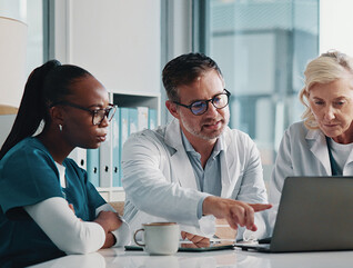 clinicians look at data on laptop