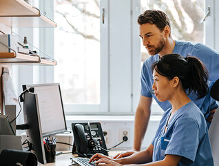 clinicians looking at computer monitor in office